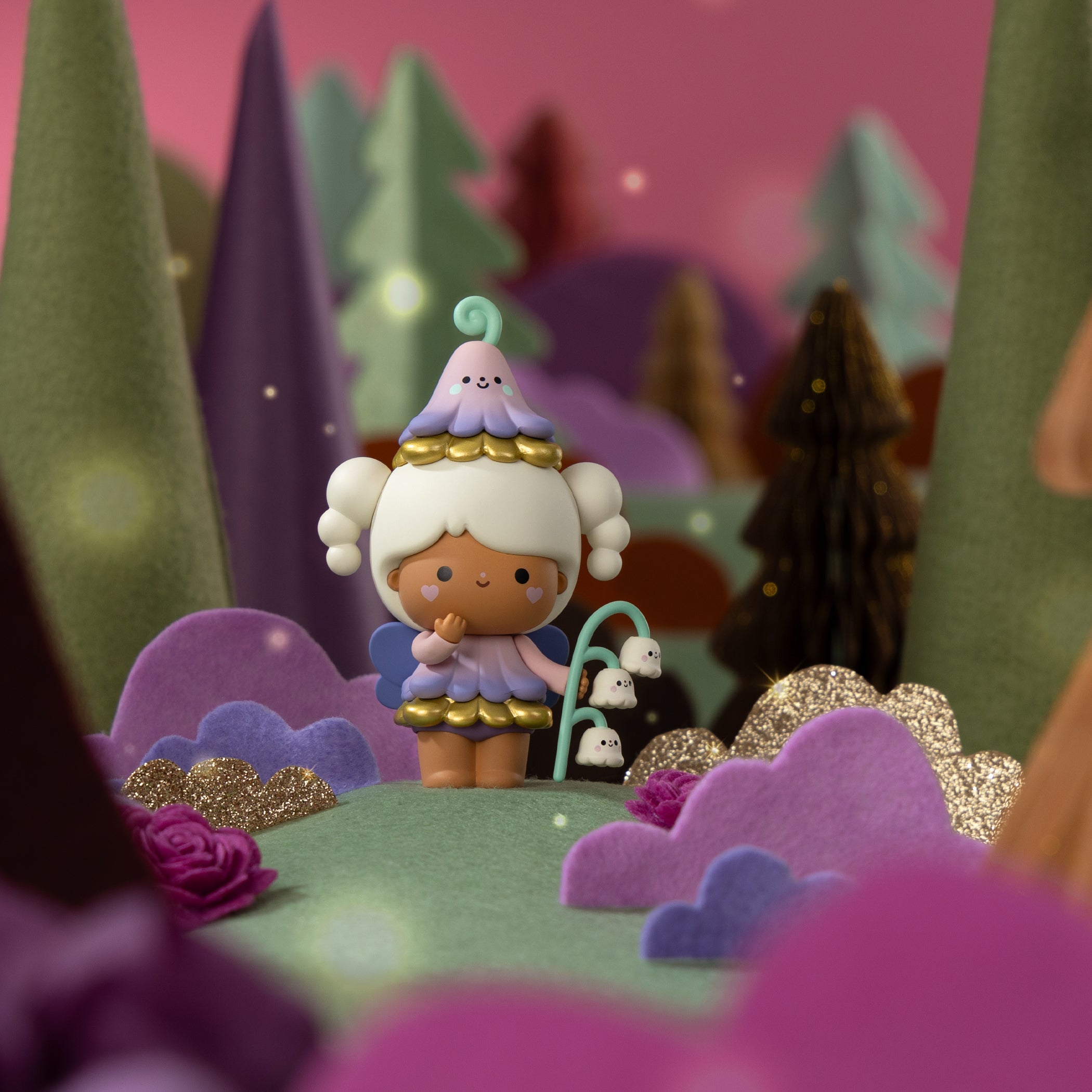 Sugar Plum Wood Momiji doll with white hair and a flower hat stands among pastel felt trees and flowers. — Momiji Doll