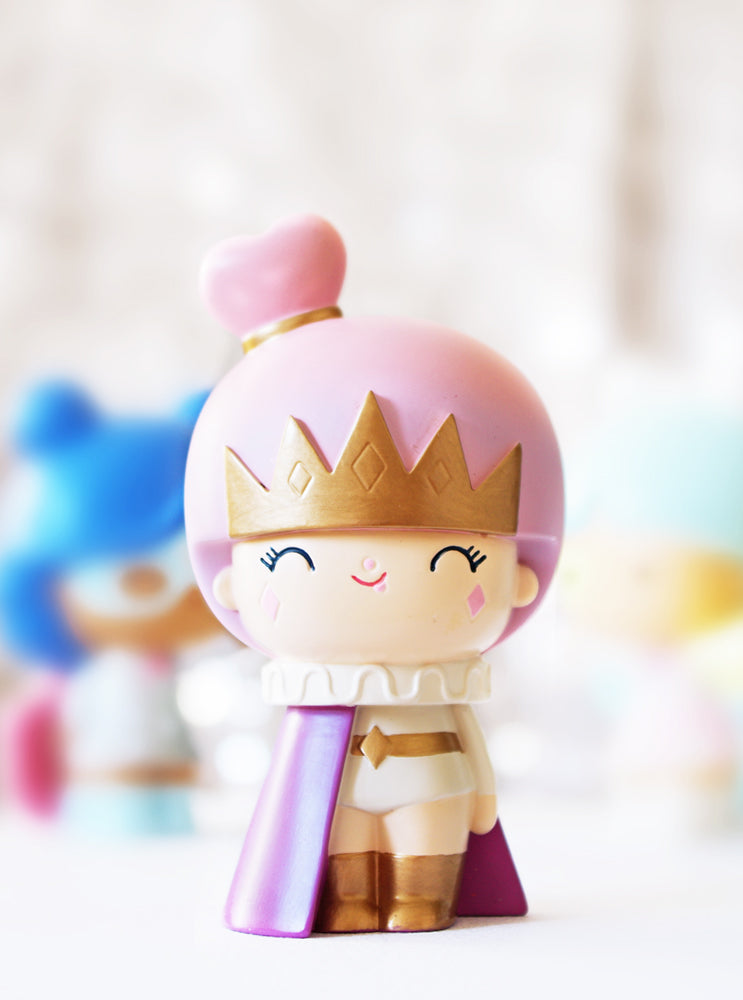 The Fabulous You Momiji doll has pink hair, a pink crown, purple cape, closed eyes, and a kawaii smile. — Momiji Doll