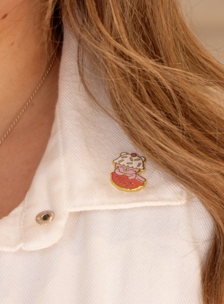 A close up of Feeling Cute Momiji doll pin, featuring a kawaii bear design, pinned on a woman's shirt. — Momiji Doll