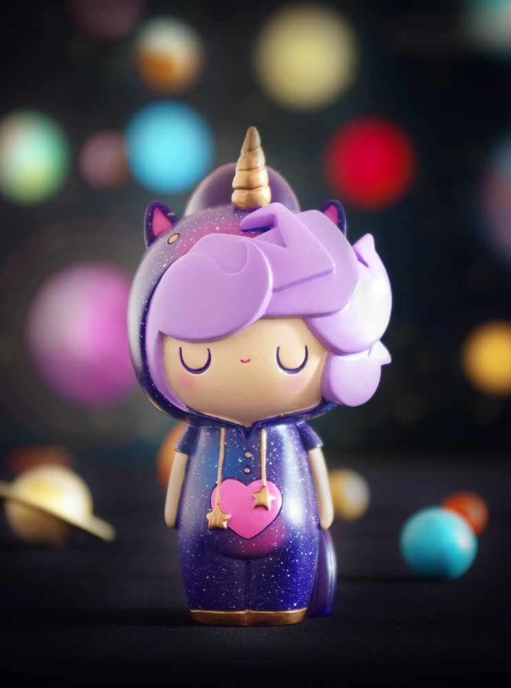 Little Starlight Girl 2021 Momiji doll as a unicorn with purple hair and heart necklace stands before a blurred space background. — Momiji Doll