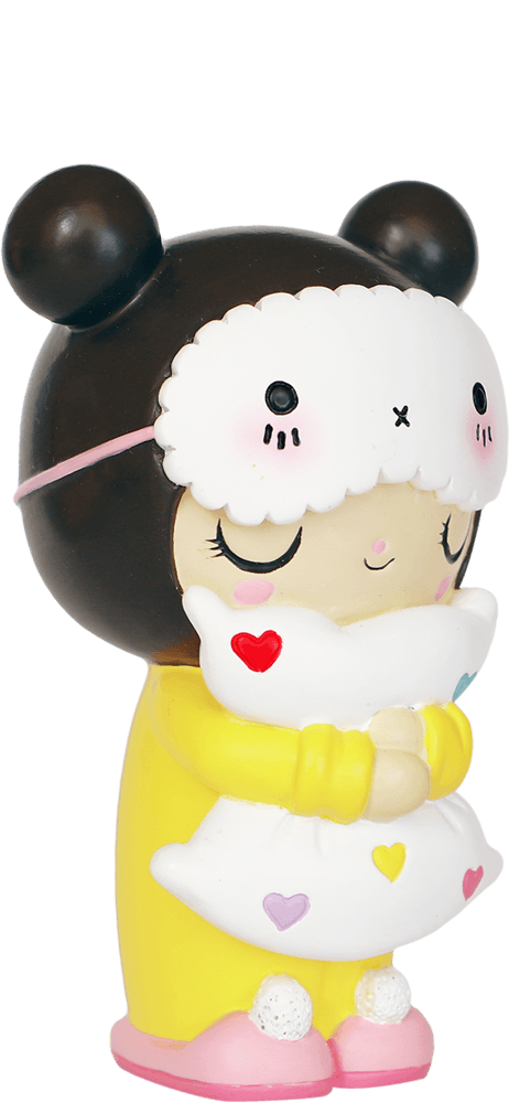 The Dreaming hn Momiji doll wears a bear hood and yellow pajamas, hugging a pillow decorated with colorful heart shapes. — Momiji Doll