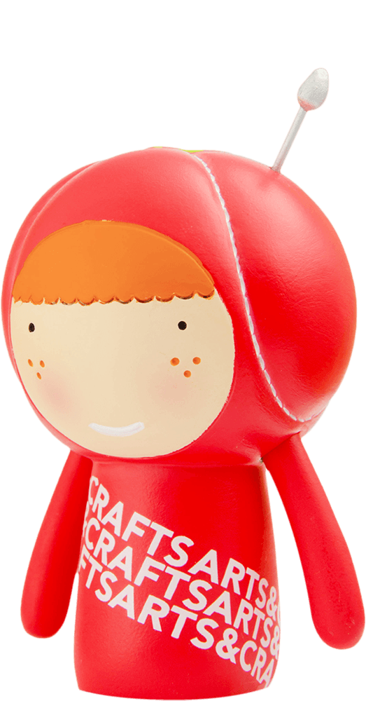 Cherie Momiji doll with red body, smiling face, orange hair, silver antenna, and "ARTS & CRAFTS" label on the front. — Momiji Doll