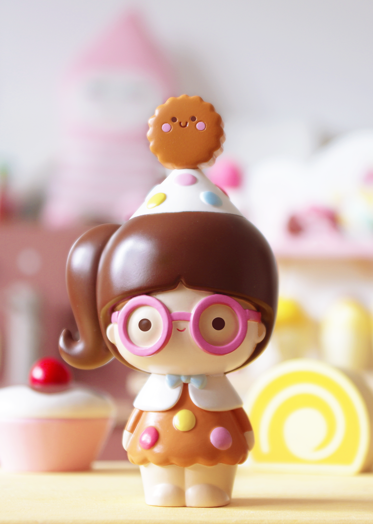 Momiji doll Smart Cookie with glasses, brown hair, candy accents, and a cookie hat stands among colorful desserts. — Momiji Doll