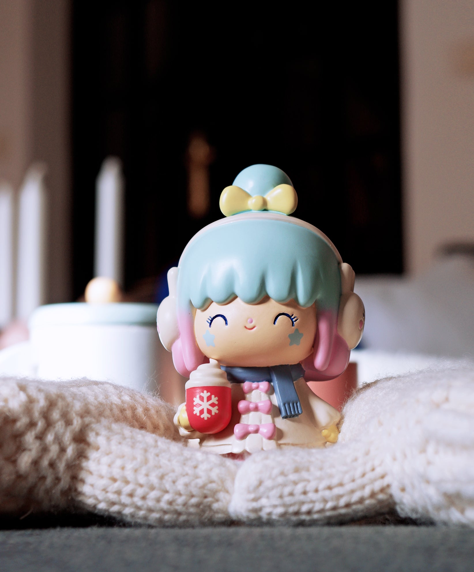 Winter Wonderland 2020 Momiji doll with earmuffs, holding a mug, sits on cozy blankets. Secret message inside. — Momiji Doll