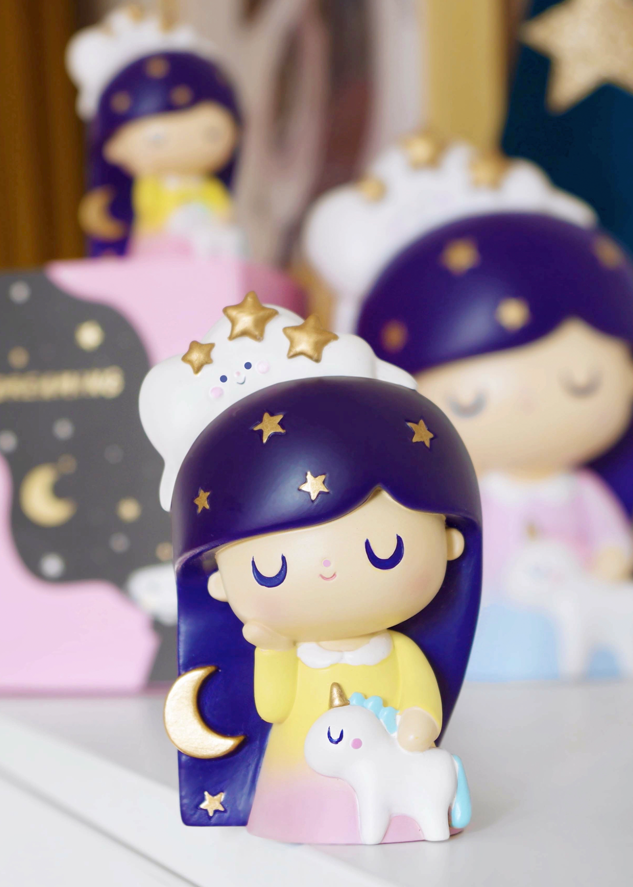 Limited edition Dreaming Momiji doll: 3" tall, purple-haired girl with moon, stars, unicorn details; blurred figures in back. — Momiji Doll