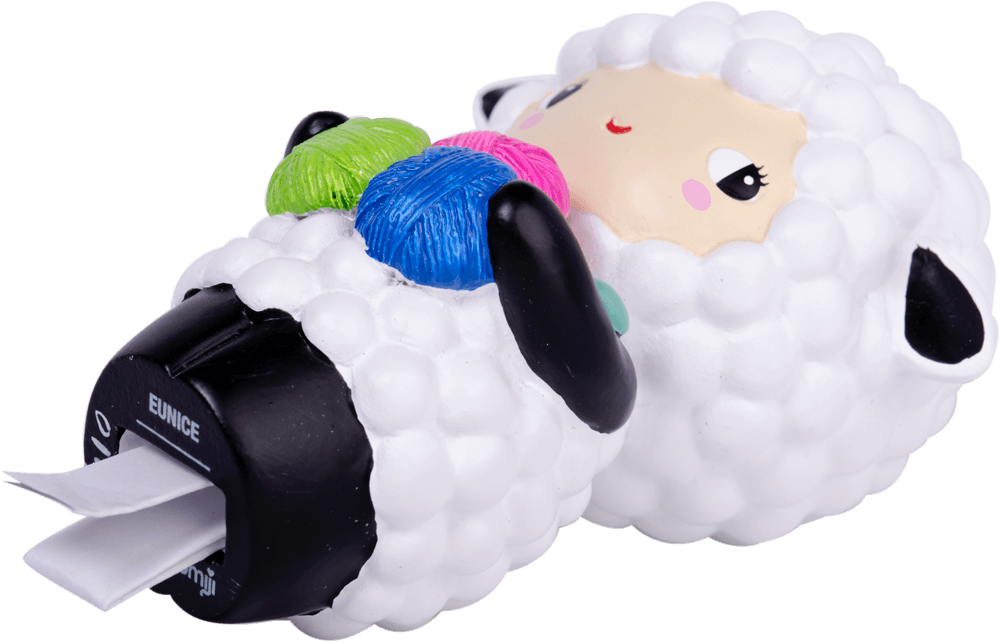 Eunice Momiji doll, shaped like a sheep, lies on its back with colorful yarn balls and tape at one end. — Momiji Doll