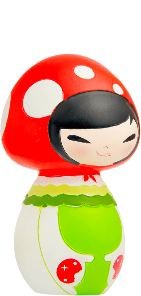 Snuggle is a kawaii Momiji doll with a red mushroom cap with white spots, black hair, green outfit, and a smiling face. — Momiji Doll
