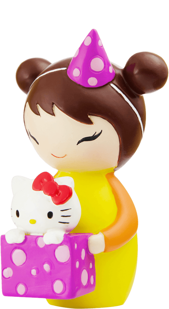 Kipi Momiji doll smiles in a party hat, holding a Hello Kitty toy and pink gift box with white dots. — Momiji Doll