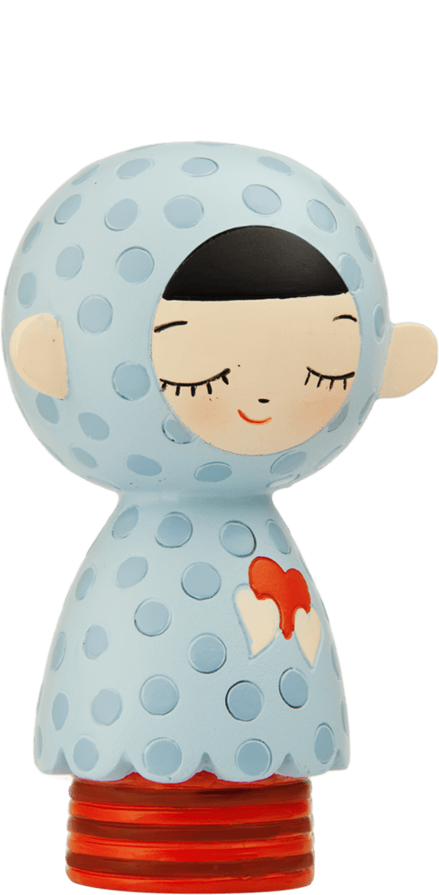 The Douce Momiji doll has closed eyes, a blue polka-dot cloak, red heart on its chest, and sits on a red base. — Momiji Doll